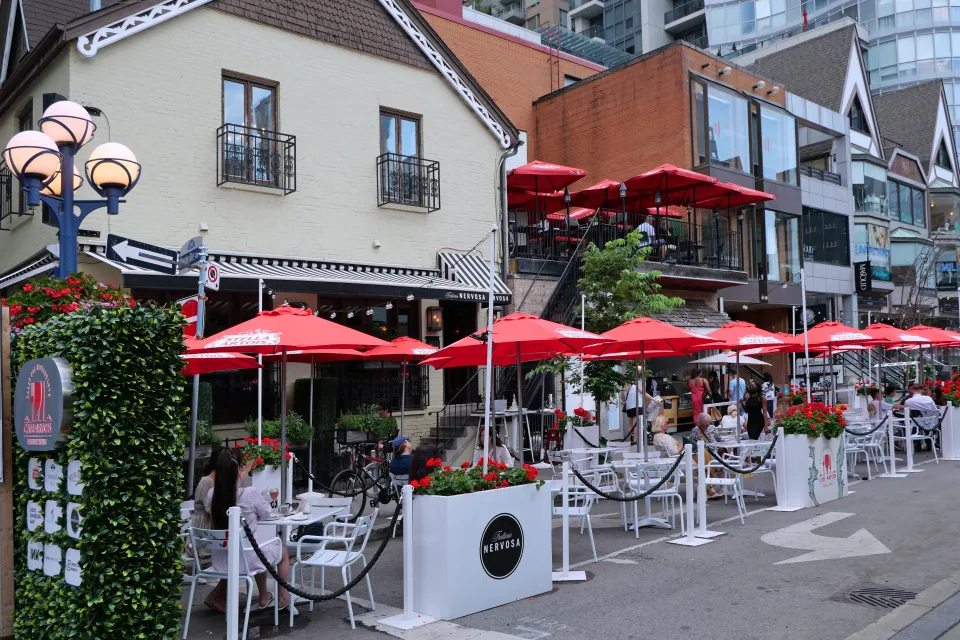 Outdoor dining patio with red umbrellas in Toronto, Canada